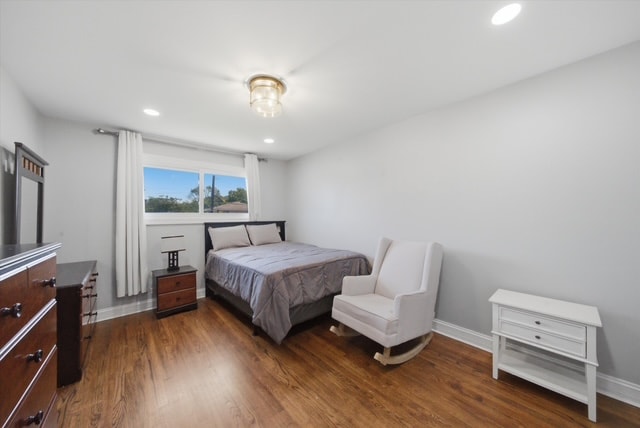 Primary bedroom with wood floors and rocking chair