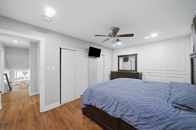 Primary bedroom with ceiling fan, blue duvet and closets